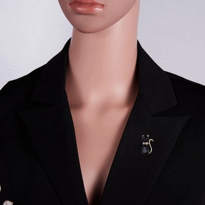 Schattige zwarte kattenbroche met gouden accenten op een revers van een zwart pak