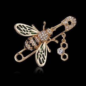 Détail de la broche abeille avec ailes en émail vert et pendentif alvéole avec cristal
