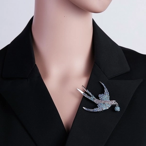 Detaillierte Nahaufnahme einer eleganten Kristall-Schwalbenbrosche mit blauen Strasssteinen