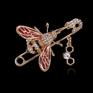 Détail de la broche abeille avec ailes en émail rouge et pendentif alvéolé serti