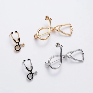 Detail view of gold and silver stethoscope brooches with sparkling rhinestone accents