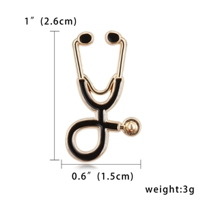 Detail showing dimensions of stethoscope brooch with height of 2.6cm and width of 1.5cm
