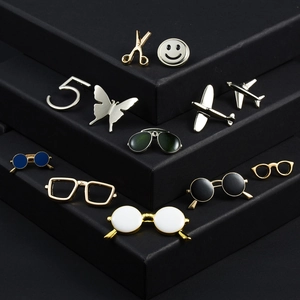 Collection of minimalist aircraft and fashion enamel pins on a professional black tiered display