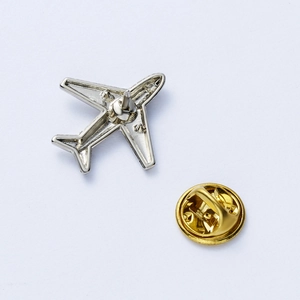 Detailed view of silver aircraft brooch with secure golden butterfly clasp hardware