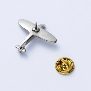 Detailed macro view of vintage silver airplane brooch with golden butterfly clutch backing