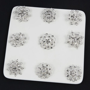 Set di 9 spille a fiore in argento con strass scintillanti su sfondo nero elegante