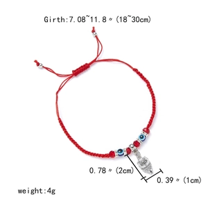 Detail of red braided evil eye bracelet featuring a silver owl charm and adjustable slide knot