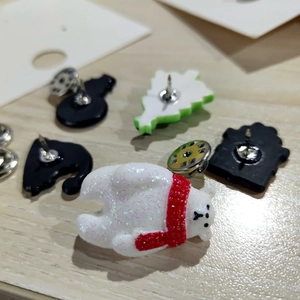 Detail of white polar bear Christmas brooch with colorful glitter and resin finish