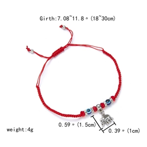 Detail of red braided evil eye bracelet with silver elephant pendant and beads