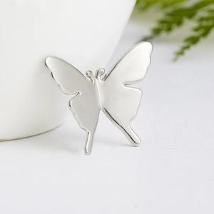 Detailed macro view of polished silver butterfly brooch with elegant glossy finish