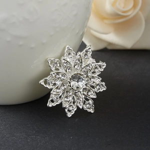 Dettaglio macro della spilla a fiore argento con cristalli lucidi su base nera