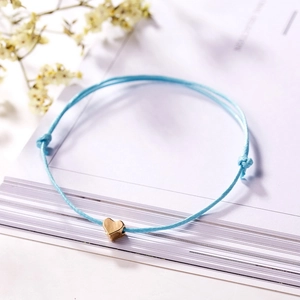 Nahaufnahme eines hellblauen geflochtenen Herz-Armbands mit verstellbarem Verschluss
