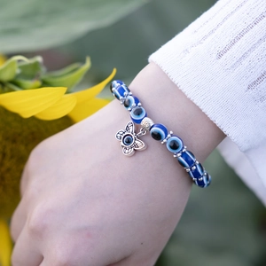Blue Evil Eye beaded bracelet with vintage silver butterfly charm on a wrist