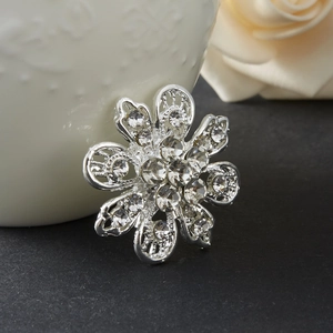 Dettaglio della spilla a fiore argento con strass di cristallo su fondo nero