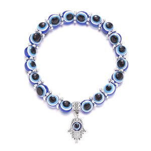 Blue Evil Eye beaded bracelet with silver Hamsa Hand charm on white background