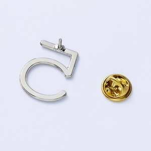 Polished silver alloy number 5 brooch with golden butterfly clasp detail on white background