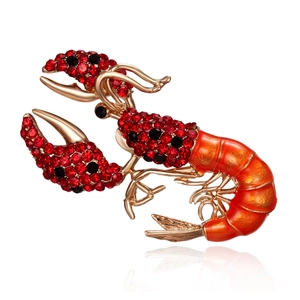 Detailed macro shot of a lobster brooch with red rhinestones and orange enamel finish