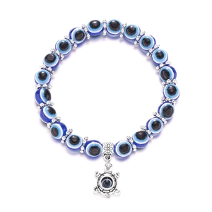 Detailed macro of Evil Eye bead bracelet featuring a silver turtle pendant on white background