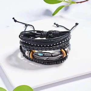Detailed macro of a multilayer leather bracelet with a silver feather pendant and turquoise stone