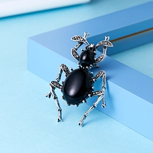 Macro shot of beetle brooch with black gemstones and vintage silver diamond inlay