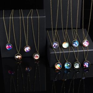 Detailed view of multiple galaxy pendant necklaces with glowing nebula glass cabochons