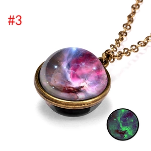 Macro detail of bronze galaxy pendant necklace with glowing nebula effect in the dark