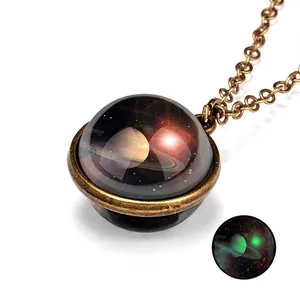 Close-up of vintage bronze galaxy necklace with luminous Saturn glass pendant glow effect