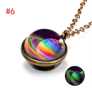 Macro view of double-sided galaxy necklace showing green glow-in-the-dark effect