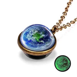Detail of vintage galaxy necklace with Earth pattern and glowing green noctilucent effect