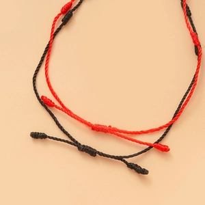 Detail van verstelbare geweven armbanden met schuifknopen in het rood en het zwart