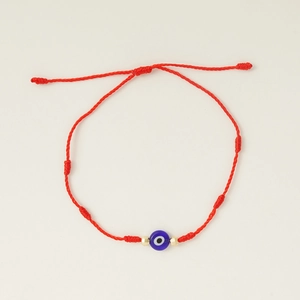 Detail van rood gevlochten armband met 7 knopen, blauwe boze oog kraal en goud