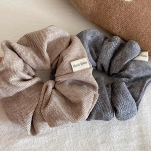 Knitted fabric scrunchies in beige and grey with a decorative Hand Made fabric label