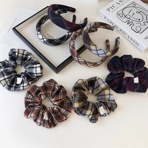 Flat lay of plaid hair scrunchies and headbands with soft wool-like texture and handmade labels