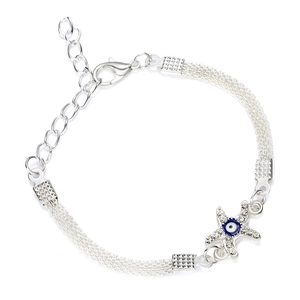 Dettaglio ravvicinato di un bracciale a maglia argento con stella marina e occhio blu