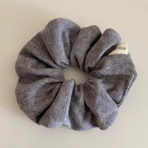 Detail showing grey ribbed knit scrunchie texture and Hand Made fabric label closeup