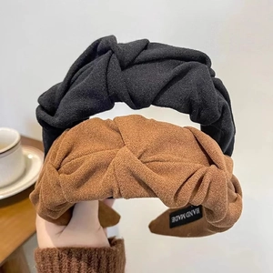 Detailed close-up of textured fabric knotted headbands in black and brown colors