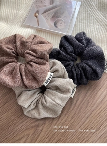 Vue détaillée de trois chouchous en maille marron et gris avec étiquettes en tissu