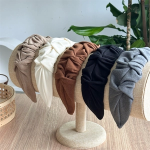 Macro shot of pleated fabric headbands showing soft texture and twisted wide-brim details