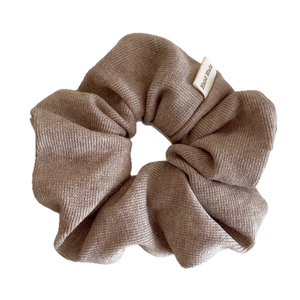 Mocha brown ribbed knit scrunchie with handmade tag showing soft elastic fabric texture