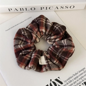 Detailed macro view of vintage plaid scrunchie with a handmade woven label detail