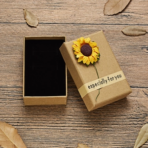 Kraft paper jewelry box with sunflower decoration on rustic wooden table background