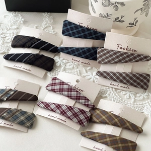 Detail of plaid and striped fabric triangle BB hair clips in vintage British style