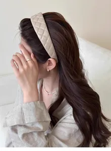 Detail of beige quilted faux leather headband showing premium texture on model