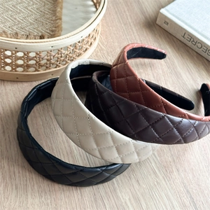 Detail of four quilted PU leather headbands in black, cream, and brown colors