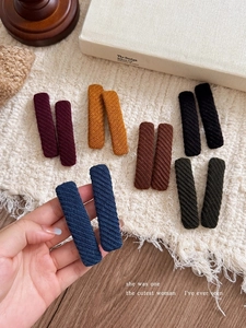 Detail of multi-colored twill fabric hair clips with knit texture in vintage style