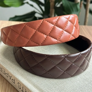 Detail of wide quilted faux leather headbands in caramel and dark brown colors