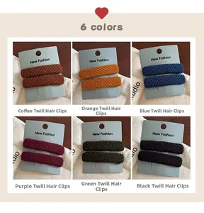 Close-up of six pairs of twill fabric hair clips in various colors on display card