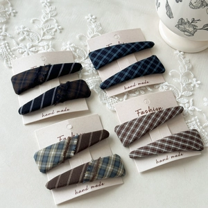 Detailed macro view of retro plaid fabric hair clips set on elegant display cards