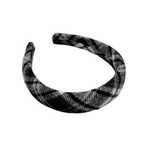 Close-up of a wide padded headband featuring classic black and white plaid fabric