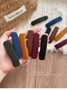 Detailed view of vintage fabric hair clips in assorted retro colors with twill texture